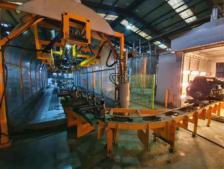 Overhead conveyor carrying WeCan implement frames through the paint booth